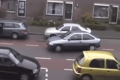 Cars Driving Down Street Including Yellow One GIF