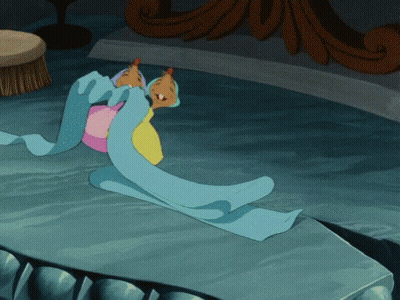 Cartoon Character Laying On Table With Blue Blanket GIF