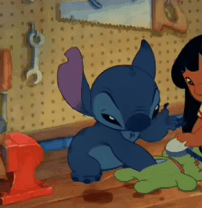 Cartoon Character On Wooden Table With Lilo And Stitch Doll GIF