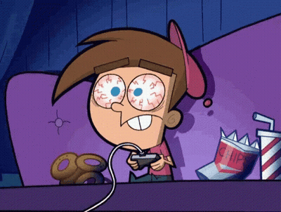 Cartoon Character Playing Video Game On Couch With Bag Of Chips GIF