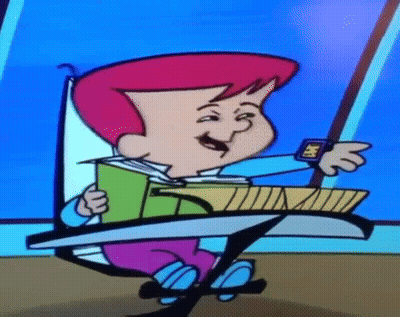 Cartoon Character Sitting At Desk Holding Book And Watch GIF