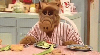 Cartoon Character Sitting At Table With Plate Of Food GIF