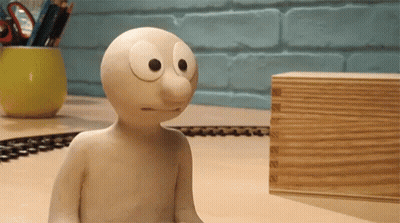 Cartoon Character Sitting On Table Next To Wooden Box GIF