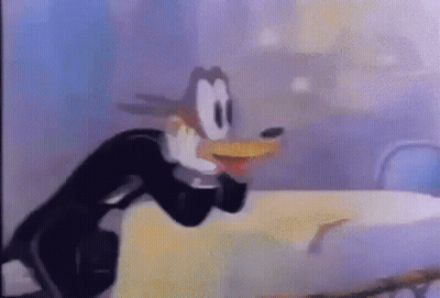 Cartoon Character Standing Next To Table GIF