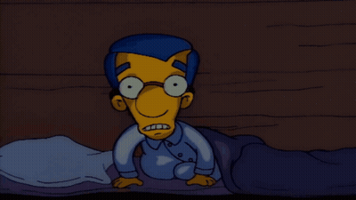 Cartoon Character With Glasses Laying On Bed GIF