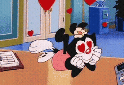 Cartoon Character With Hearts In Eyes Sitting On Pink Pillow GIF