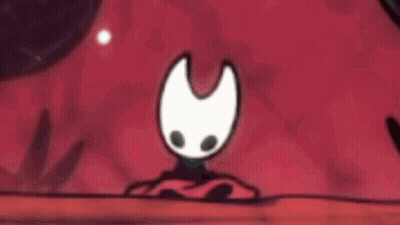 Cartoon Character With White Face And Black Eyes Sitting On Red Cloth GIF
