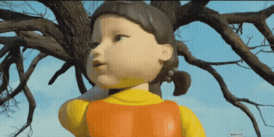Cartoon Doll Standing In Front Of Tree GIF