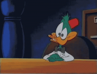 Cartoon Duck In Tuxedo Sitting At Table GIF