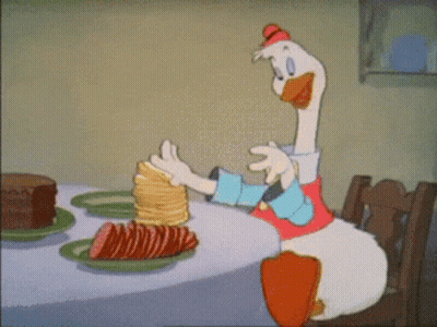 Cartoon Duck Sitting At Table With Pancakes And Cake GIF