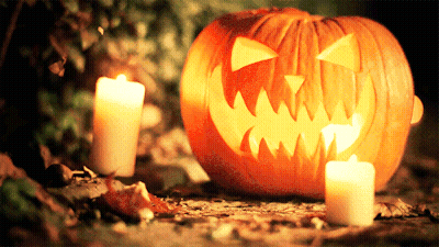 Carved Pumpkin With Two Lit Candles GIF