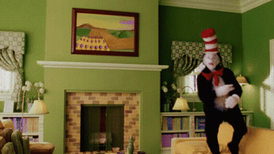 Cat In The Hat Standing By Fireplace GIF