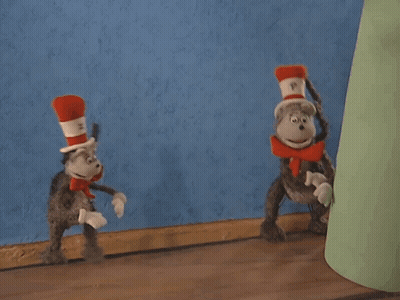 Cat In The Hat Standing Next To Stuffed Animal GIF