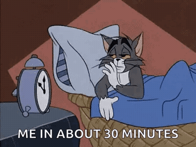 Cat Lying In Bed With Alarm Clock GIF