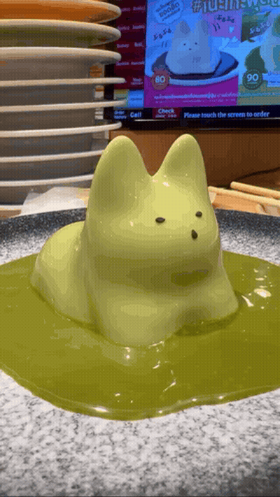 Cat Statue Sitting On Green Liquid GIF