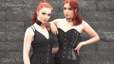 Celene Nox Is Standing Next To Another Woman In A Corset GIF