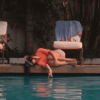 Chair With Blue Towel Next To Pool GIF