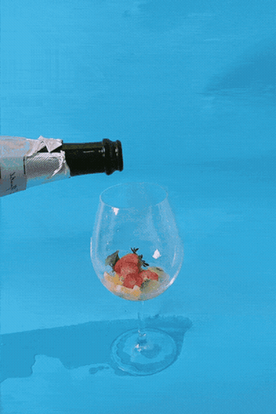 Champagne Poured Into Glass On Blue Surface GIF