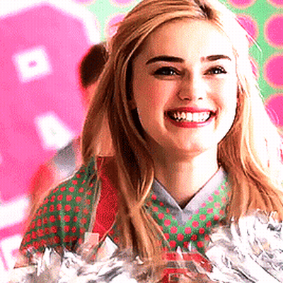 Cheerleader In Green And Red Polka Dot Shirt Smiling GIF