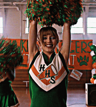 Cheerleader In HS Uniform Holding Pom Poms Above Head GIF