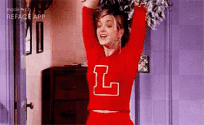 Cheerleader In Red Sweater With Letter L Holding Pom Poms GIF