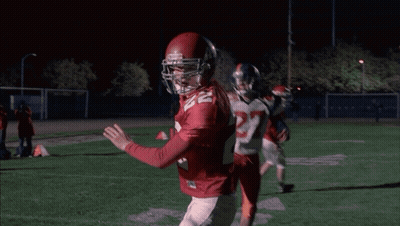 Cheerleader In WMHS Uniform Next To Man In Red Sweater GIF