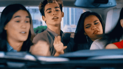 Cheerleader In WMHS Uniform Smiling Next To Man In Green And White Striped Shirt GIF