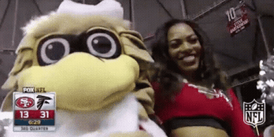 Cheerleader Posing With Mascot At Football Game GIF