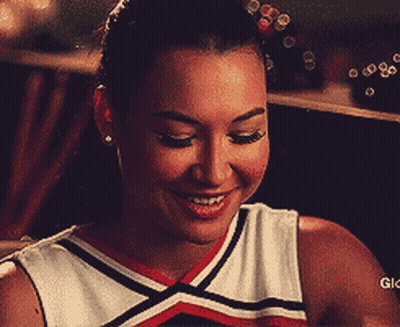 Cheerleader Smiling Holding Stick In Mouth GIF