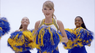 Cheerleaders In Blue And Yellow Holding Pom Poms GIF
