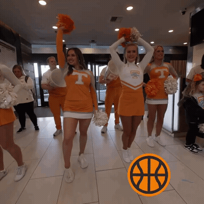Cheerleaders In Orange Uniforms With The Letter T On Their Shirts GIF