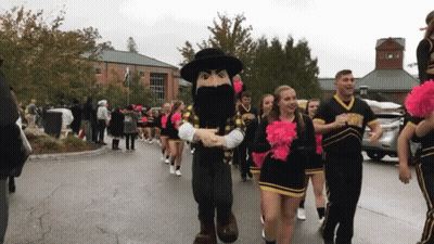 Cheerleaders Marching With Mascot In Black Hat GIF