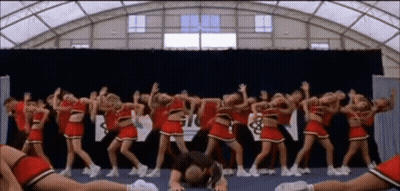 Cheerleaders Performing In Front Of Gil Sign GIF