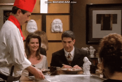 Chef-Hatted Man Cooking For Woman And Suited Man GIF
