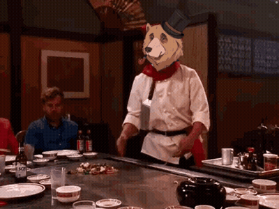 Chef In Top Hat With Bear Head At Table GIF