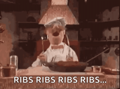 Chef Repeating Ribs While Holding Fork In Mouth GIF