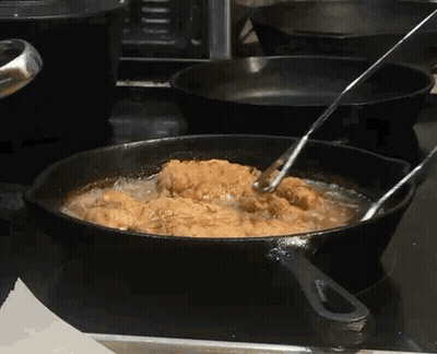 Chicken Is Being Cooked In A Frying Pan On A Stove GIF