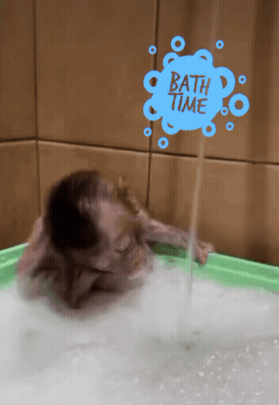 Child Bathing In Green Tub With Bath Time Sign GIF