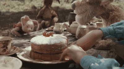 Child Cutting Cake At Picnic Table GIF