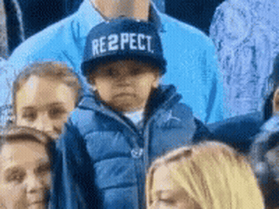 Child In Respect Hat Sitting In Crowd GIF