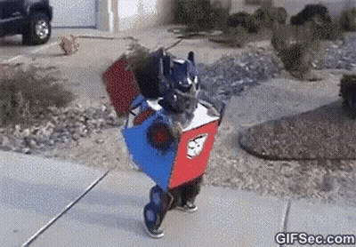 Child In Robot Costume Walking Down Sidewalk GIF