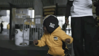 Child In Yellow Jacket With Letter M GIF