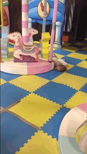 Child Lying On Playground Floor GIF