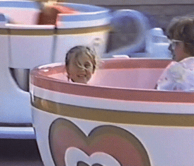 Child Riding Pink And White Tea Cup With Heart GIF