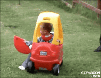 Child Sitting In Red And Yellow Toy Car GIF