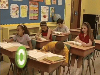 Children Sitting At Desks With Green Circle Saying C GIF