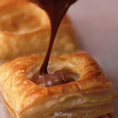Chocolate Is Being Poured Into A Pastry That Says Mr.cakes On It GIF