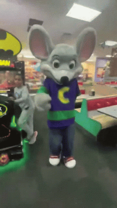 Chuck E Cheese Mascot In A Purple Shirt With A Yellow C On It GIF