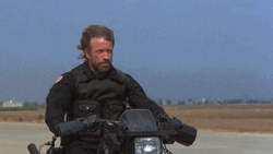 Chuck Norris Firing Guns Through Motorcycle GIF