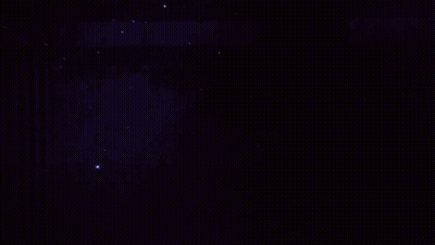 City At Night With Green Light From Sky GIF